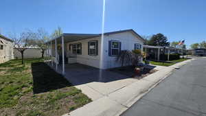 View of front of home featuring driveway and a carport