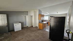 Living room with visible vents, brown cabinetry in kitchen, and recently cleaned carpet