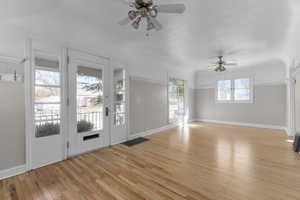 Entrance foyer with ceiling fan, baseboards, visible vents, and light wood-style floors