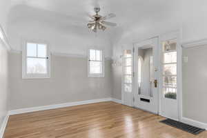 Entryway featuring light wood-style floors, ceiling fan, visible vents, and baseboards