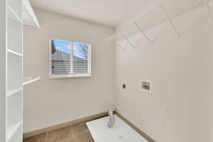 Laundry room featuring baseboards, laundry area, washer hookup, and hookup for an electric dryer