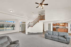 Living room with visible vents, stairway, dark colored carpet, and a wealth of natural light