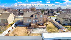 View of front facade featuring a mountain view, a fenced backyard, a residential view, and stucco siding