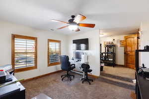 Office space with carpet floors, visible vents, baseboards, and a ceiling fan