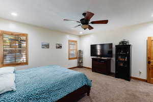 Bedroom featuring a ceiling fan, baseboards, carpet flooring, and recessed lighting