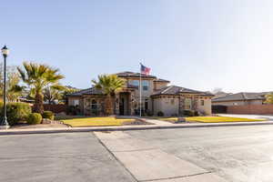 Mediterranean / spanish-style home featuring stone siding, a tile roof, fence, and stucco siding