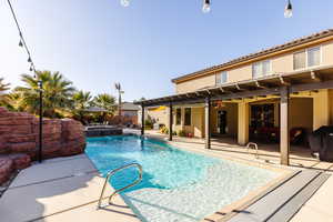 View of pool featuring a pool with connected hot tub, a patio area, and ceiling fan