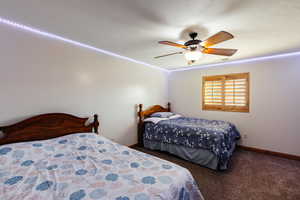 Bedroom with a textured ceiling, carpet flooring, visible vents, a ceiling fan, and baseboards