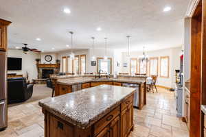 Kitchen featuring appliances with stainless steel finishes, a kitchen island with sink, stone tile flooring, a sink, and recessed lighting