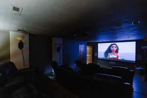 Cinema with visible vents and a textured ceiling