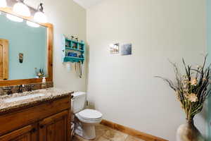 Bathroom with vanity, toilet, and baseboards