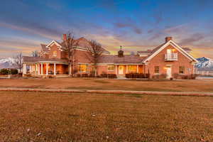 Traditional-style house featuring brick siding, a chimney, and a yard