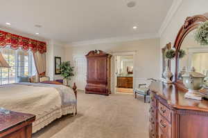 Bedroom with light carpet, ensuite bath, crown molding, and recessed lighting