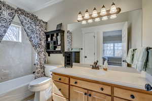 Full bathroom with a wealth of natural light, crown molding, vanity, and toilet