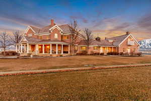 View of front of property featuring a chimney, a front lawn, and brick siding