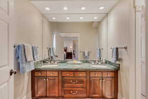 Full bathroom featuring double vanity, a sink, and recessed lighting