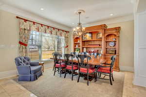 Dining space featuring baseboards, ornamental molding, and a chandelier