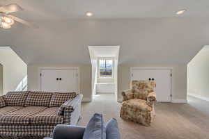 Living area featuring recessed lighting, light colored carpet, a ceiling fan, vaulted ceiling, and baseboards