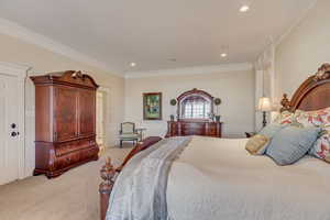 Bedroom with recessed lighting, baseboards, crown molding, and light colored carpet