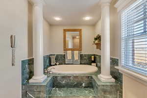 Bathroom with decorative columns and a bath