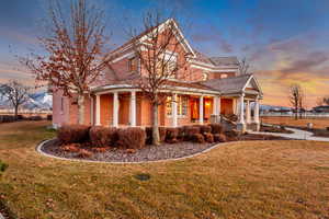 View of front facade featuring brick siding, a porch, and a front yard