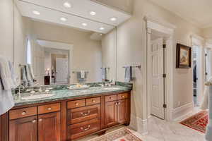 Full bath featuring recessed lighting, a sink, baseboards, and double vanity