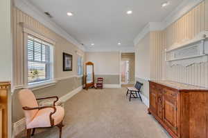 Living area featuring recessed lighting, light carpet, crown molding, and baseboards