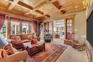 Carpeted living area featuring ornamental molding, recessed lighting, coffered ceiling, and beamed ceiling