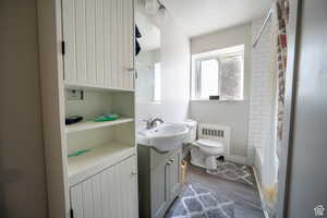 Bathroom featuring toilet, radiator heating unit, a textured ceiling, vanity, and wood finished floors