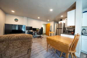 Interior space with light wood-style floors, recessed lighting, a textured ceiling, and baseboards