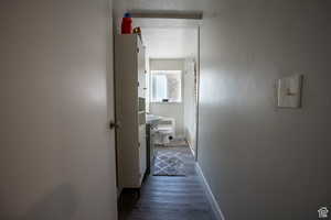 Hallway featuring a textured ceiling, dark wood-style flooring, and baseboards