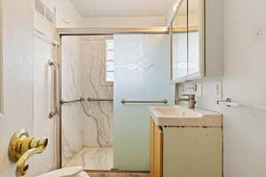 3/4 bathroom Basement with marble finish floor, visible vents, vanity, and a marble finish shower