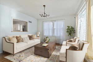 VIRTUAL STAGING - Living Room with a textured ceiling, wood finished floors, visible vents, and a notable chandelier