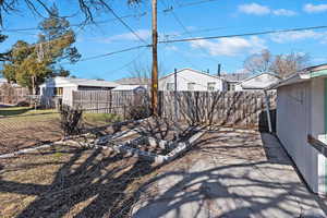 View of yard with a garden, a fenced backyard, and a residential view