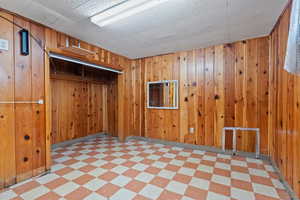 Empty room featuring light floors and wood walls