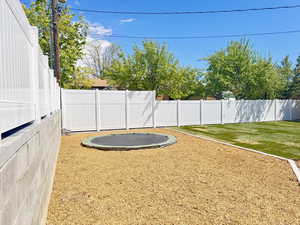 View of yard featuring a fenced backyard and a trampoline