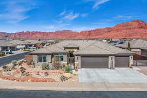 Single story home with a garage, concrete driveway, a mountain view, and stucco siding