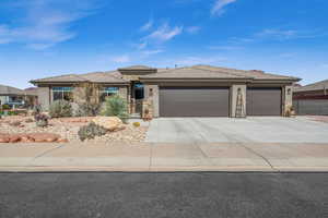 Prairie-style home with driveway and stucco siding