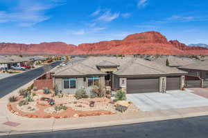 View of front of home with concrete driveway, an attached garage, fence, a mountain view, and stucco siding