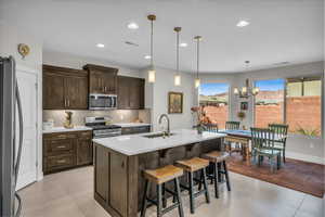 Kitchen featuring stainless steel appliances, light countertops, visible vents, backsplash, and a sink