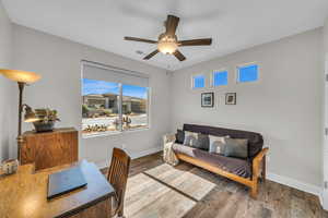 Office space featuring ceiling fan, visible vents, baseboards, and wood finished floors