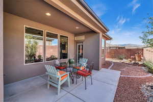 View of patio with outdoor dining area, fence, and a mountain view