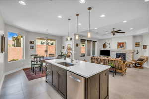 Kitchen with dishwasher, a fireplace, a sink, and recessed lighting