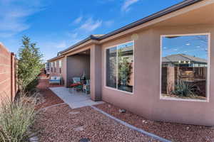 View of home's exterior featuring a patio area, fence, and stucco siding