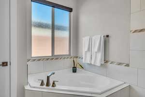 Full bath featuring a bath and a wealth of natural light