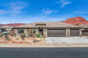 Prairie-style house with an attached garage, a mountain view, fence, concrete driveway, and stucco siding