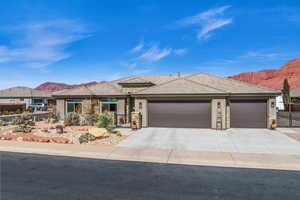 View of front facade with a garage, fence, a mountain view, and stucco siding