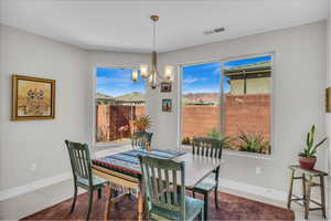 Dining room featuring visible vents, plenty of natural light, a notable chandelier, and baseboards