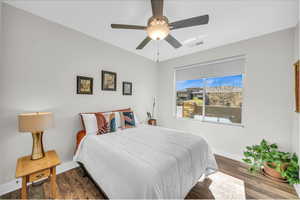 Bedroom featuring baseboards, visible vents, ceiling fan, and wood finished floors