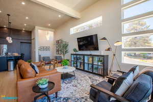 Open living room which includes all furniture, TV, and view the front door to enter the home from this angle.